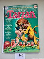Front cover photo of the comic book showing title, pricing, and artwork of Tarzan fighting a lion with other jungle animals.