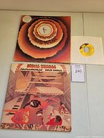Top-down photo showing two Stevie Wonder vinyl album covers and one 45 RPM insert record sleeve with yellow-label record visible