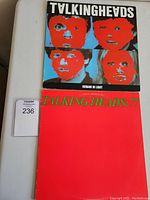 Two Talking Heads vinyl records stacked, showing the cover art for 'Remain In Light' and 'Talking Heads: 77'.