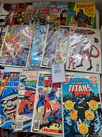 Photo showing a set of Marvel and DC comics including Teen Titans Annual #2, Amazing Spider-Man #797 variant, and others stacked in plastic sleeves.