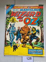 Front cover showing colorful characters Dorothy, Tin Man, Cowardly Lion, Scarecrow, and Toto on the yellow brick road. Comic is titled Marvel and DC present MGM's Marvelous Wizard of Oz with big bold letters.