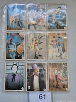 Nine 1966 Batman Batlaffs non-sports cards in protective sleeves, showing various characters and scenes from the series.