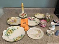 Overview of the full ceramic collection showing plates, cups, and a decorative bottle on a countertop
