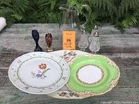 Entire collection showing all items arranged on wooden table with greenery in background.