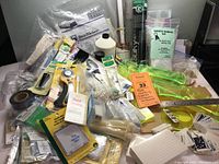 Wide view of entire quilting supplies lot showing templates, needles, rotary cutter, tape, stabilizer, scissors, thread cones, and other related quilting tools and accessories.