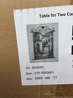 Close-up photo of box label with style and SKU details showing canvas artwork image