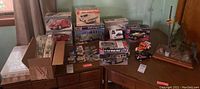 Photo showing multiple boxed car model kits and assembled/displayed parts on a table
