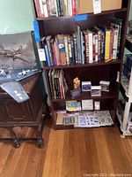 Photo of bookshelves showing multiple military books and model airplane kits.