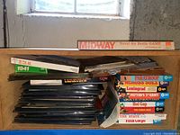 Top shelf showing Midway Naval-Air Battle Game box on right and stacked game boxes below