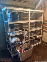 Two white plastic shelving units filled with various items to show scale and condition.