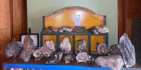 Full collection arranged on wooden display labeled Oxford Mills Pegmatites