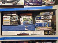 Shelf view showing multiple aircraft kits, USS Enterprise and large USS Arizona box