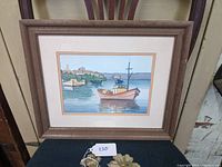 Full view of the framed watercolor painting depicting fishing boats moored near shore with a wooden frame.
