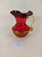 Front angled view of amberina glass pitcher showing gradient coloration and wavy rim