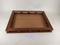 Angled view showing wooden tray slatted sides and base with attached tag.