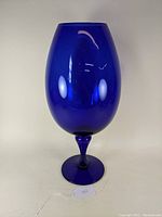 Front view of the Mid Century Italian Empoli cobalt blue glass vase showing its tall, oval shape and pedestal base.