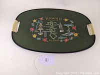 Oval mid century souvenir serving tray with Hawaiian map and colorful flowers, hula dancer, palm tree, canoe, and monkey statue illustrations.
