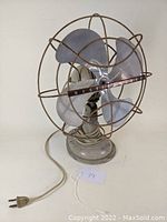 Front view of vintage Westinghouse electric fan showing metal blades, wire cage and front brand bar.