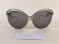Front view of vintage Foster Grant sunglasses showing large translucent gray rounded frames and dark lenses with tag '125'