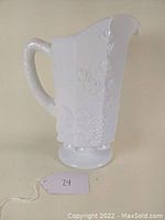 Side angle showcasing the pitcher handle, spout, and grape pattern detail on the panel.