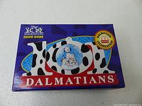Front of box with '101 Dalmatians Snow Dome' title and image of snow globe with dalmatian figures inside