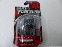 Front view of the packaged Autobot Jazz Transformers robot figure showing the packaging and figure details.