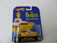 Front view of Hot Wheels The Beatles Yellow Submarine toy in original packaging highlighting branding and vehicle design.