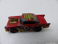 Front-side view of the red 1976 Hot Wheels 57 Chevy model with sci-fi graphics and gold engine block.