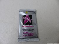 Front view of sealed silver foil pack with Star Trek 25th Anniversary logo and text indicating 12 cards included.