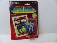 Photo of unopened Ertl 1990 DC Comics Super Heroes Batman figure in original blister pack with comic cover artwork backing.