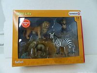 Boxed set showing all four animal figurines inside clear packaging with yellow and brown safari-themed background and Schleich branding.