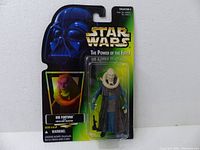 Front view of Star Wars Bib Fortuna figure in original packaging, showing figure and packaging design including Darth Vader image and product branding.