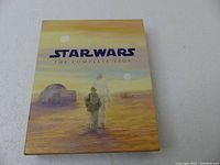 Front cover of Star Wars The Complete Saga Blu-Ray box showing characters on a desert background with twin suns.