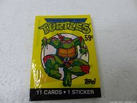 Front view of sealed Teenage Mutant Ninja Turtles 1989 Topps trading card pack with yellow background and Raphael character illustration.