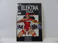Front cover of The Elektra Saga #1 comic book showing Elektra in red with sword and Marvel logo.