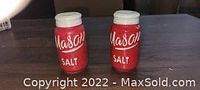 Two red salt shakers shaped like Mason jars with white lids and the text 'Mason SALT' on their fronts.