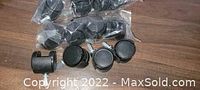 Three sets of black caster wheels for plastic storage bins, some sealed in plastic packaging