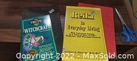 Four metaphysical-themed books on a wooden floor: "The Truth About Witchcraft," "Reiki and Crystal Living," "Cults in America," and "A Dictionary of Satanism."
