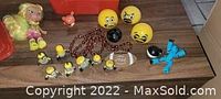 Full view of all items including Minion figurines and keychains, yellow stress balls, Minecraft Creeper figure, small doll and copper bead necklace.