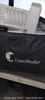Close-up photo of black LimoStudio branded carrying case with bulb visible inside