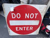 Front view of round 'Do Not Enter' traffic sign with visible wear and marks.