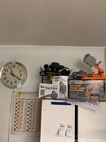 View of Timex electric wall clock, Bonaire shop blower and box, Chicago electric chain saw sharpener and box on shelf