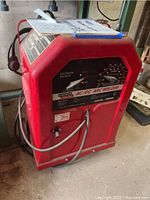 Front view of red Lincoln Electric AC/DC Arc Welder showing control panel and carrying handle