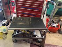 Front perspective showing black ribbed rubber platform, scissor mechanism and overall lift table structure