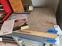 Front view of Starrett granite surface plate with manual on top, displaying the speckled pink granite surface and blue taped measurement label.