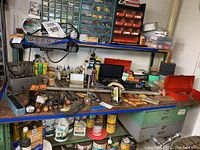 Overview of workbench with assorted tools, hardware bins, paint cans, and toolbox