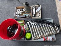 Full view of all items including Craftsman wrenches, oil can, trailer hitch, oil filter wrenches, timing light, buffer, and metal tray
