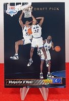 Front view of the 1993 Upper Deck Shaquille O'Neal rookie card showing player performing dunk and dribble in Magic uniform.
