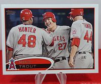 Front view of 2012 Topps Mike Trout 2nd year baseball card showing Trout with teammates Hunter and Toribo in Angels uniforms.