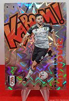 Front of the holographic Kaboom card featuring Aleksandar Mitrovic in white Fulham kit with BetVictor sponsor, with colorful zigzag background and bold Kaboom text